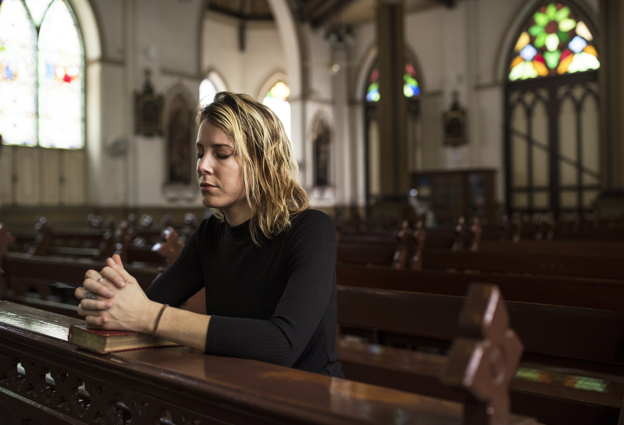 young woman kneeling prayer church